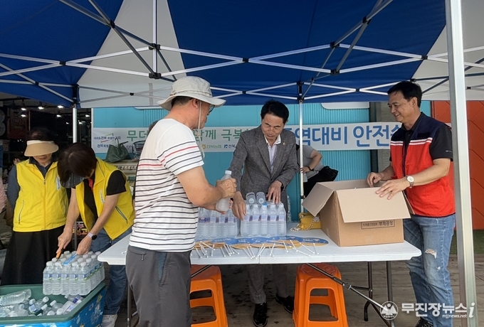 8월 14일(목) 진안장날에 열린 폭염 대비 안전쉼터 운영 현장에서 전용태 전북특별자치도의원(왼쪽 두 번째)과 백경태 전북특별자치도 대외협력국장(오른쪽 첫 번째)이 군민들에게 얼음물과 부채를 나누고 있다.